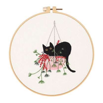 Embroidery hoop with a black cat and floral design on white fabric