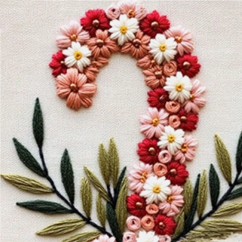 Embroidery design of a candy cane made with flowers and leaves on a white background