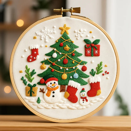 Embroidery hoop with Christmas-themed design including a tree, snowman, stockings, and presents.