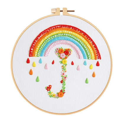 Embroidery hoop with a colorful rainbow and floral elements on white fabric.