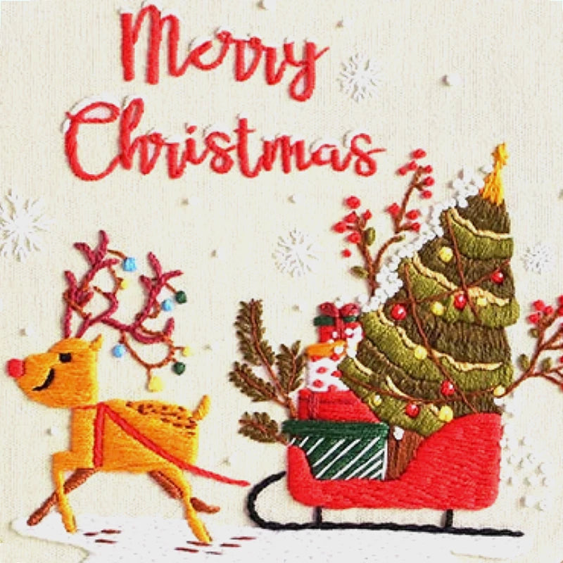 Embroidered design of a reindeer pulling a sleigh with a Christmas tree, surrounded by festive elements on a white background.