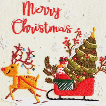 Embroidered design of a reindeer pulling a sleigh with a Christmas tree, surrounded by festive elements on a white background.