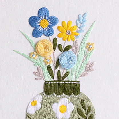 Spring Vase captures the gentle charm of blooming flowers in a simple green vase — a celebration of new beginnings and quiet beauty. The soothing mix of blue, yellow, and mint green threads brings a fresh, elegant touch to your home décor, perfect for brightening up any space.