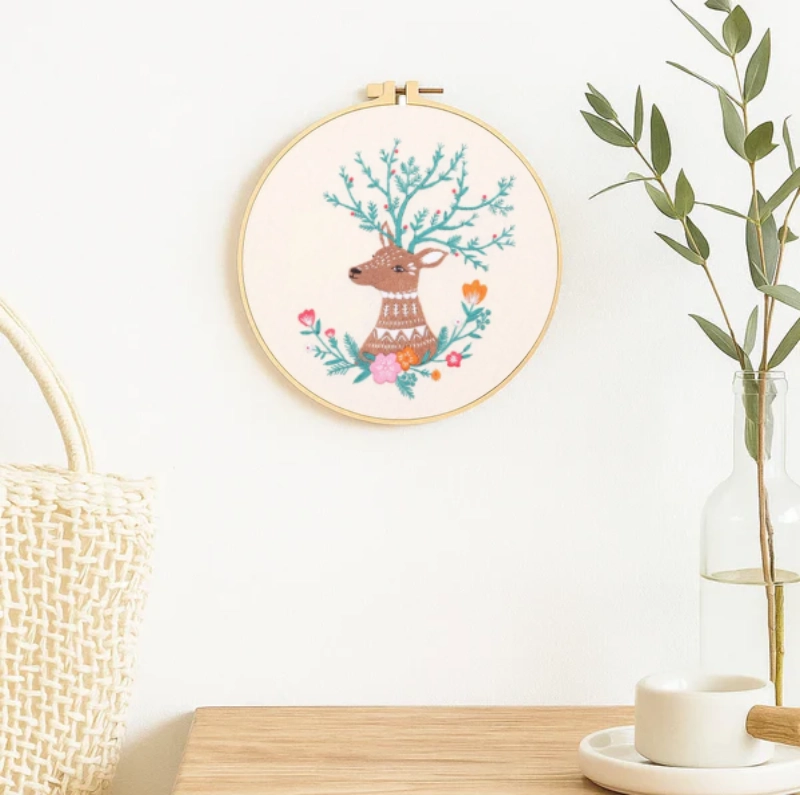 This embroidery piece features a gentle deer with branch-like antlers adorned with delicate flowers and leaves. The soft color palette creates a warm, soothing atmosphere, making it a perfect decorative piece to bring a touch of woodland serenity into your home.