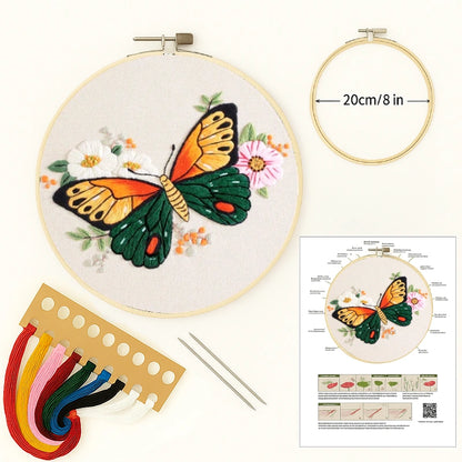 Embroidery kit with butterfly design, hoop, threads, and instructions on a white background