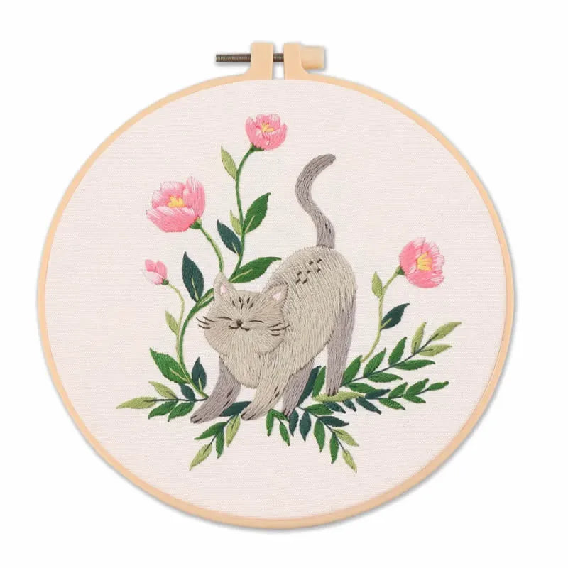 Embroidery hoop with a cat and floral design on a white background