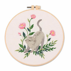 Embroidery hoop with a cat and floral design on a white background