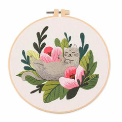 Embroidery hoop with a cat and floral design on a white background